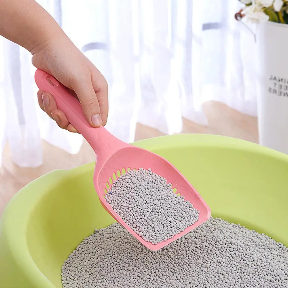 Pink plastic cat litter shovel with perforated scoop and long handle
