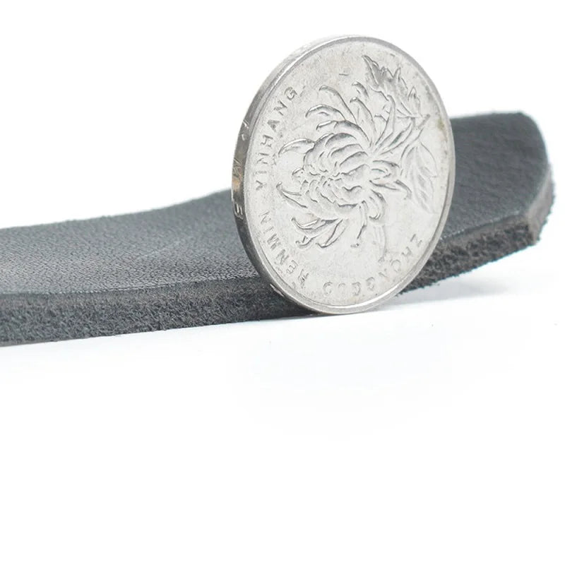 Black leather dog harness strap close-up with stitching and silver-tone snap buckle