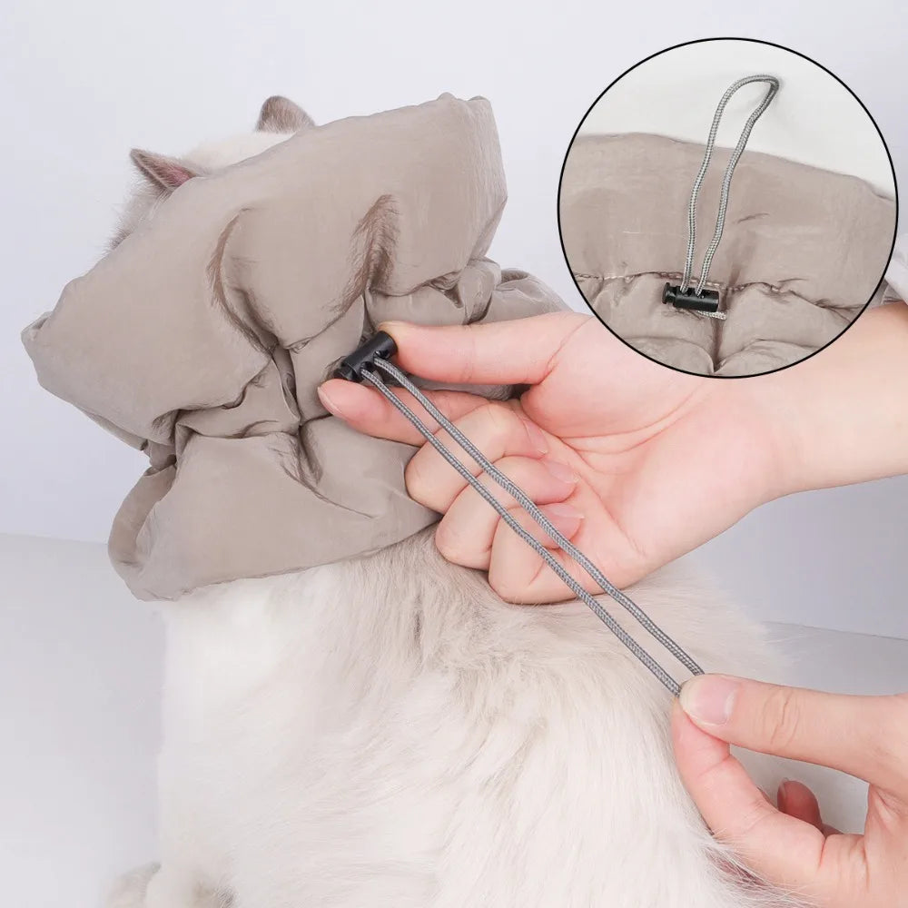 Beige cat recovery collar with adjustable tie strap, shown being fastened