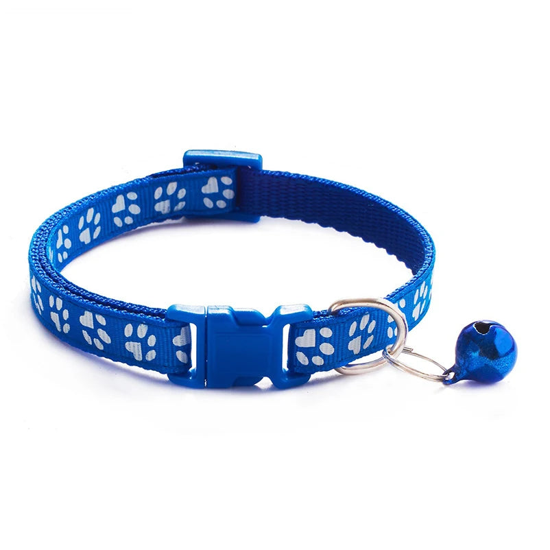 Blue paw-print cat collar with plastic buckle and bell charm on a ring