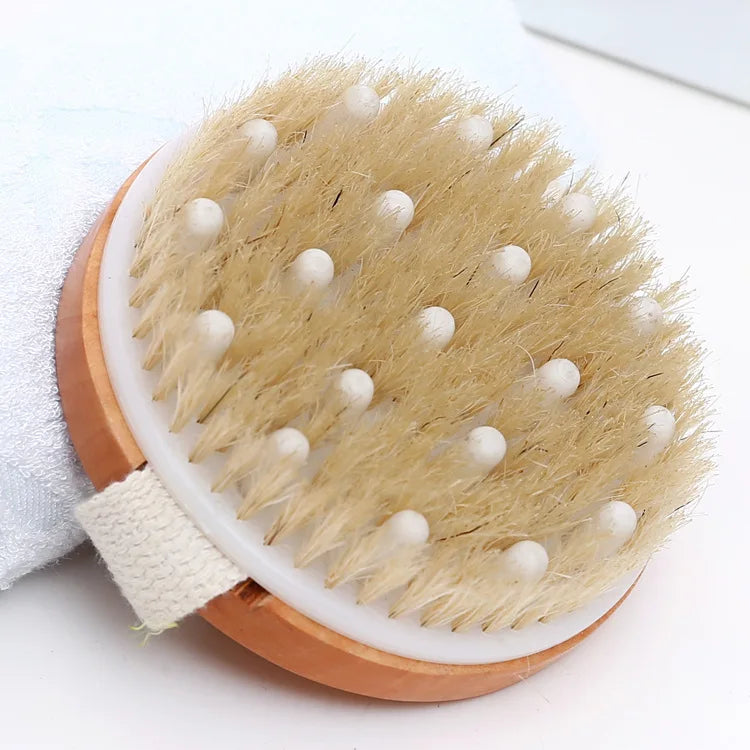 Pet bath brush head with beige bristles and white nubs on light wood base