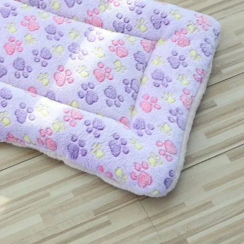 Lavender plush pet blanket mat with multicolor paw prints and thick padded corners