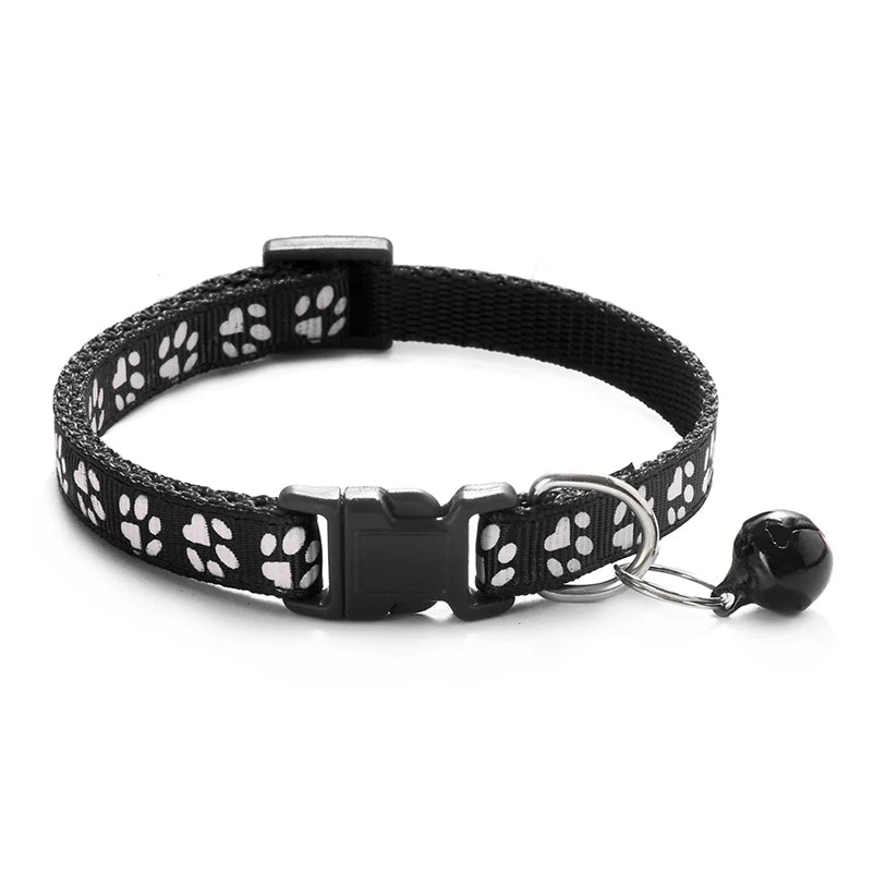 Black paw-print cat collar with plastic buckle and bell charm on a ring