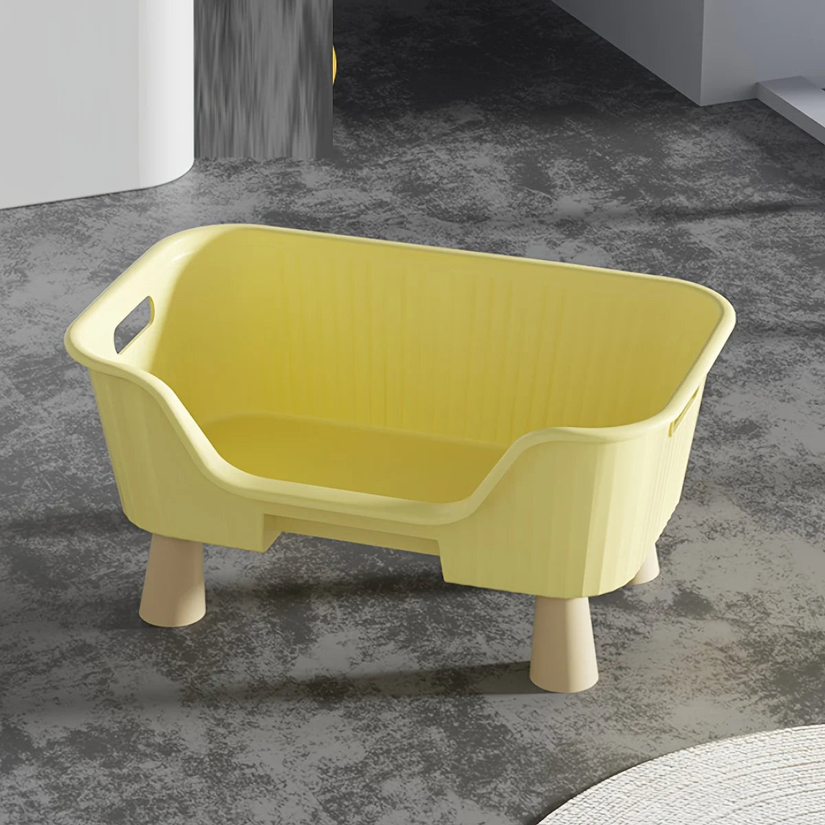 Yellow cat bed with white frame, rounded front opening and raised wooden legs.