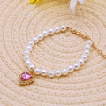 Pet white pearl necklace collar with pink heart-shaped crystal pendant and gold chain.