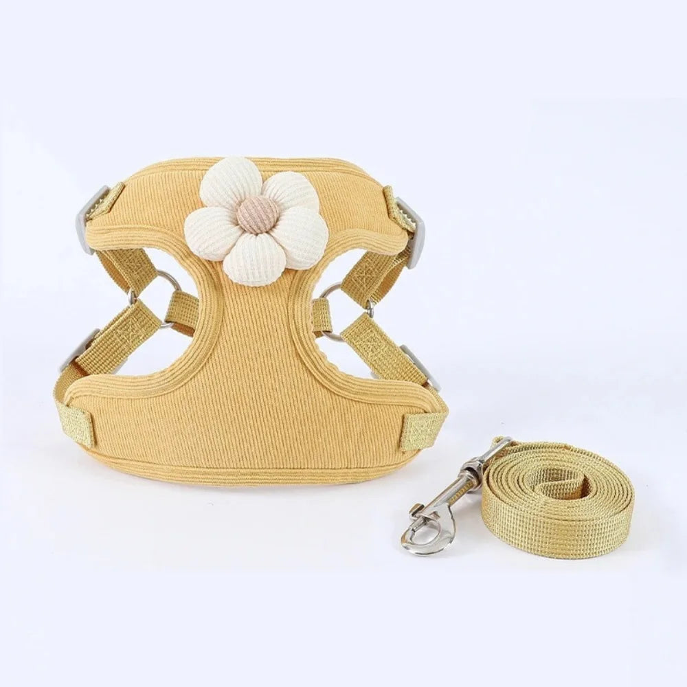 Yellow dog harness set with white flower patch and matching leash strap on white background