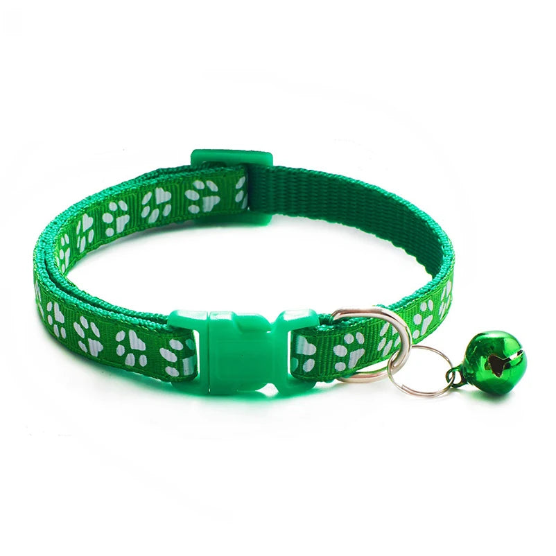 Green paw-print cat collar with plastic buckle and bell charm on a ring