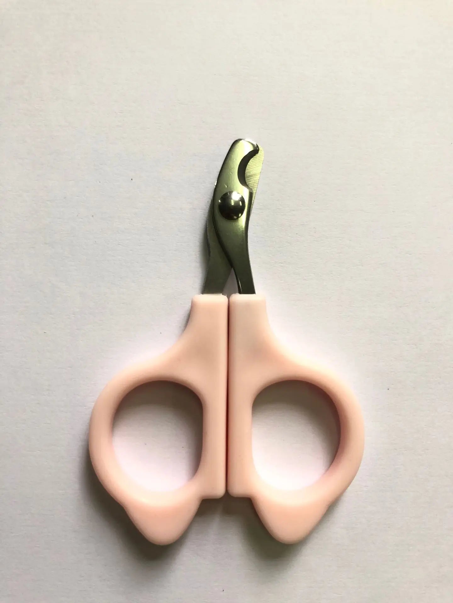 Pet nail clipper scissors with light pink handles and silver cutting blades