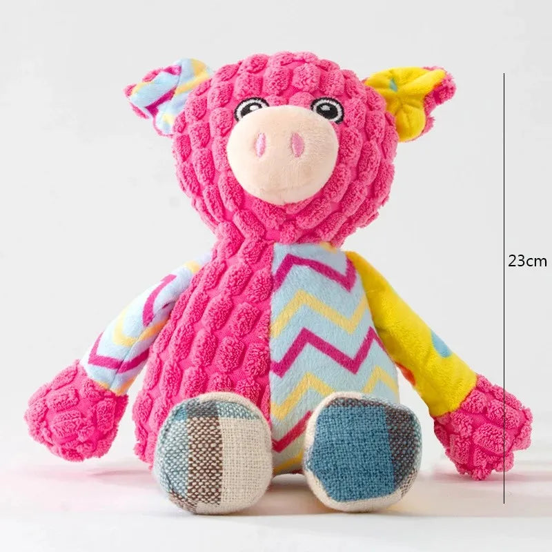 Pink pig-shaped squeaky plush toy with zigzag vest and patchwork feet, 23cm