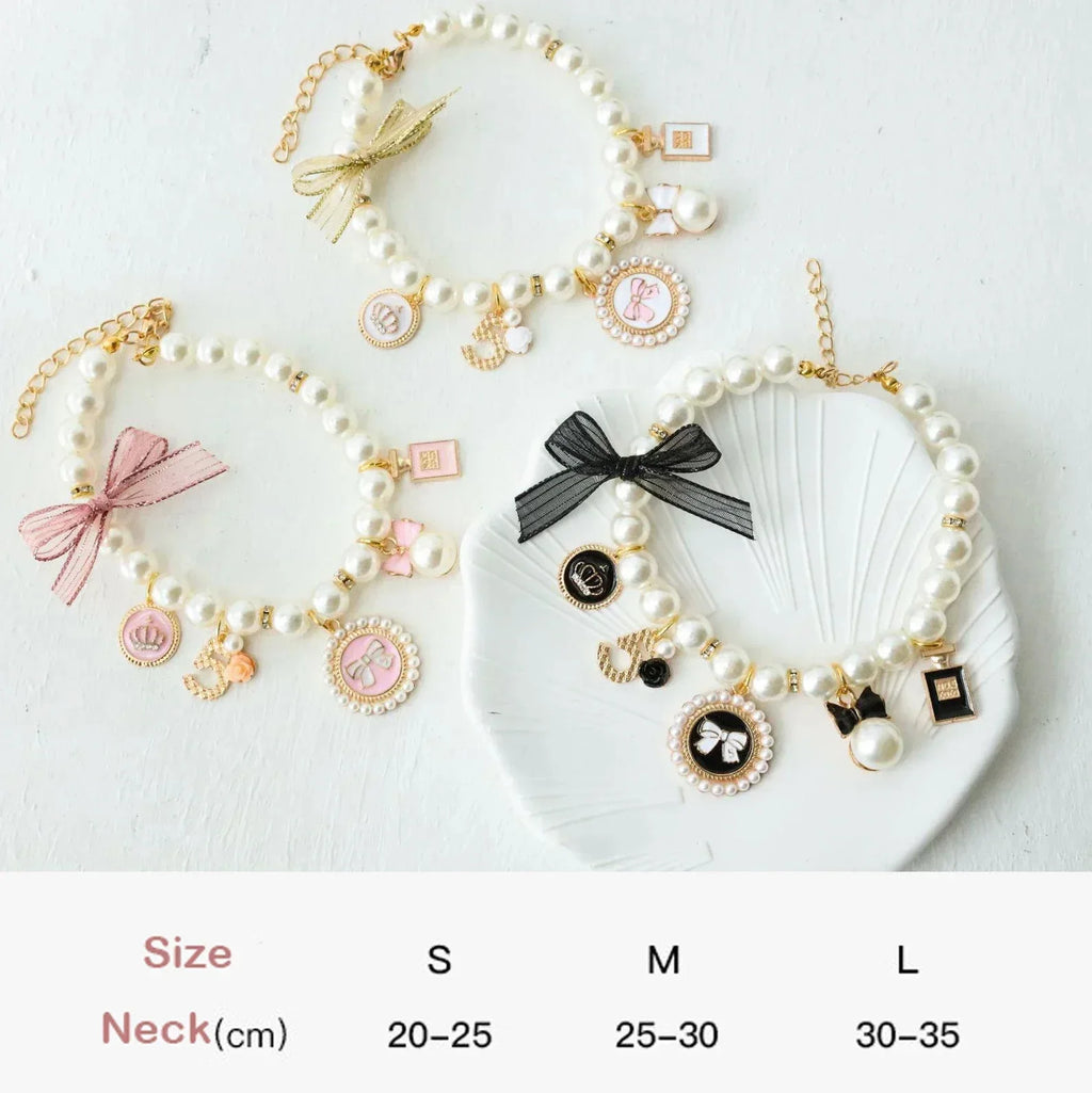 Three pearl pet collars with different lace bows and charm pendants, white beads