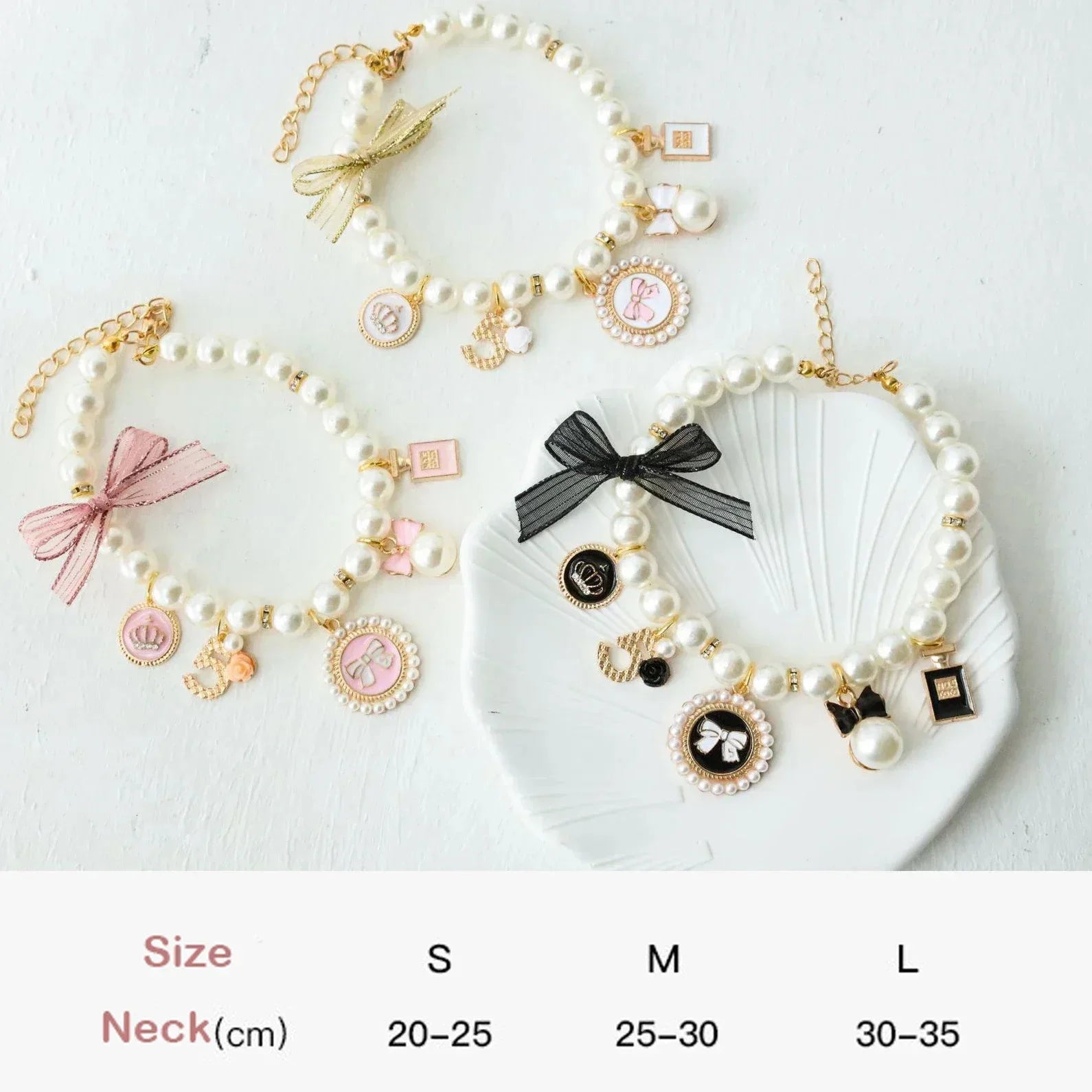 Three pearl pet collars with different lace bows and charm pendants, white beads