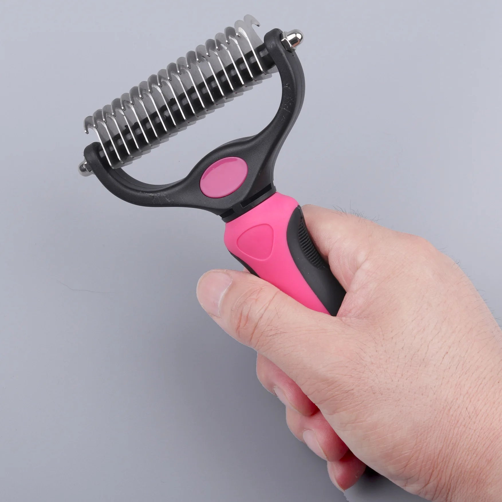 Dual-side shedding comb with pink-and-black handle, curved frame, stainless teeth