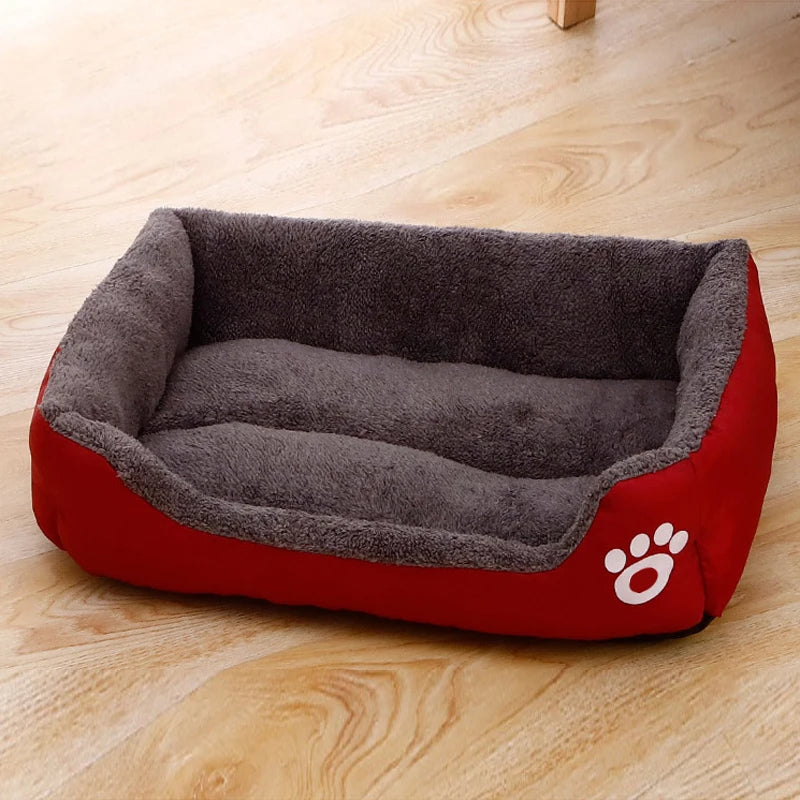 Plush dog bed with gray inner lining and red outer base, paw logo on side