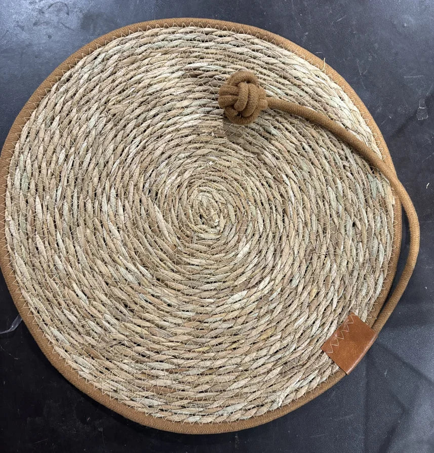 Natural rattan cat scratching mat with rope ball toy on top, close-up view