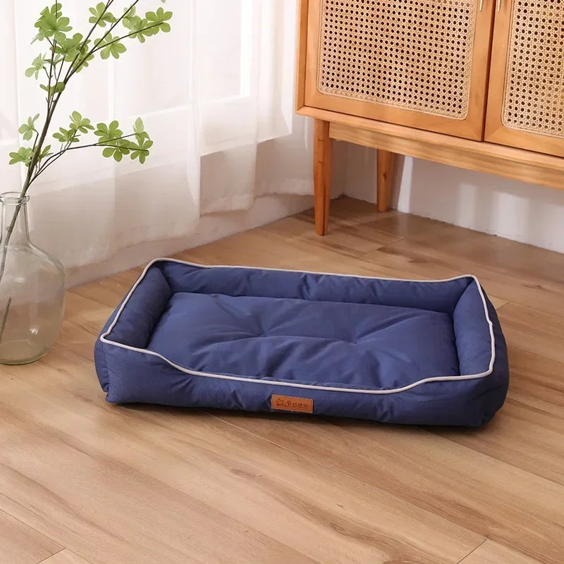 Blue rectangular dog bed with raised sides and light piping trim along the outer rim