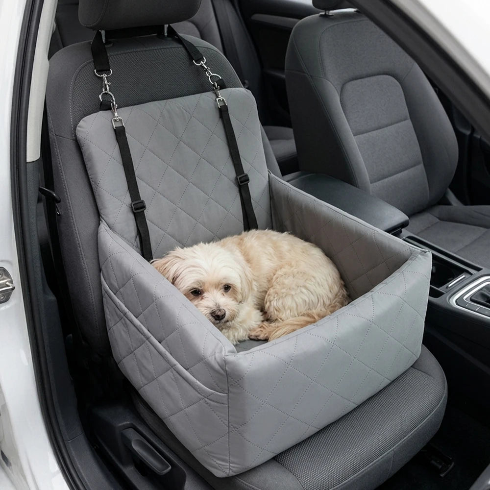 Light gray quilted dog booster seat in car with tether straps and a lying dog