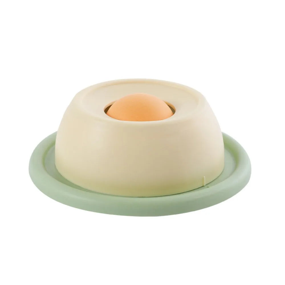Beige and pale green cat licking toy bowl with orange ball insert