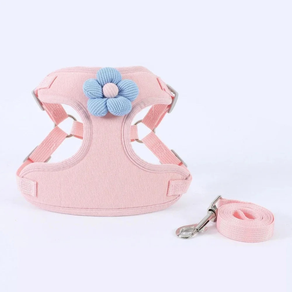 Pink dog harness set with flower patch and matching leash strap on white background