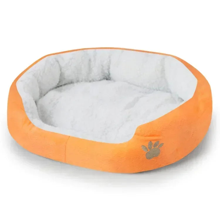 Plush oval dog bed with orange outer cover, white inner cushion, and paw print detail