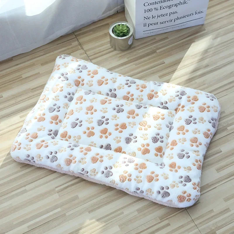 White plush pet sleeping mat with paw-print pattern and cushioned folded shape