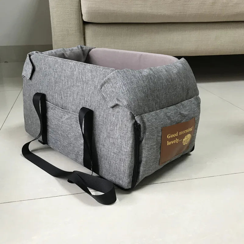 Grey dog car seat bed with side handles and shoulder strap, padded walls and zipper panel