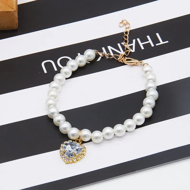 White pearl pet necklace collar with round crystal pendant and gold chain clasp.