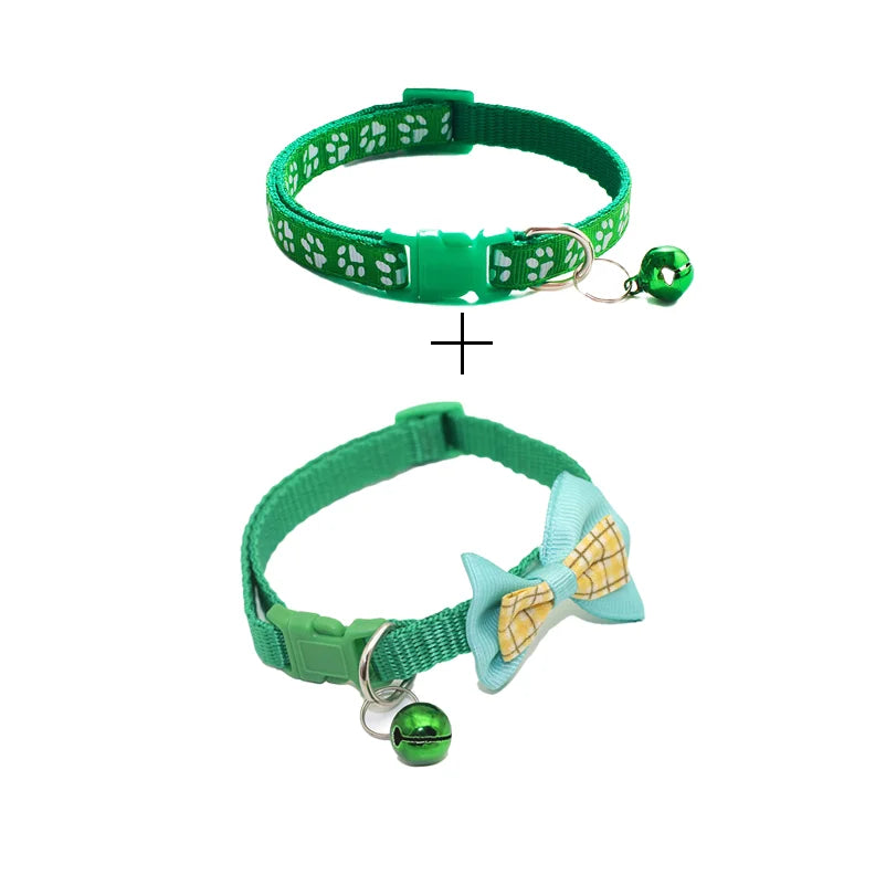 Two green cat collars with paw-print pattern and small bell charms