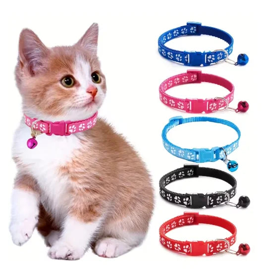 Cat wearing adjustable pink cat collar with bell and paw-print pattern
