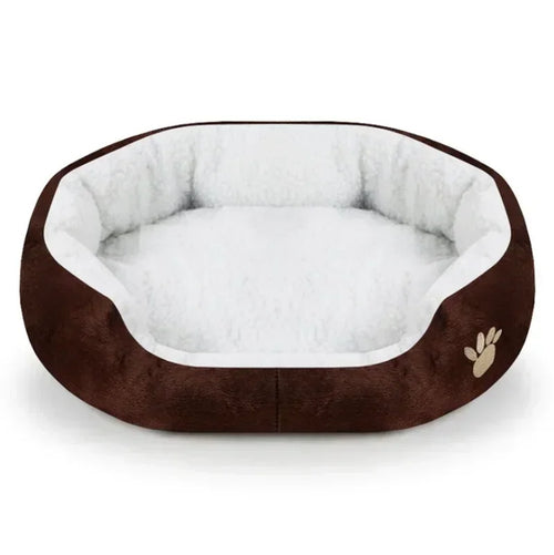 Plush oval dog bed with dark brown outer cover, white inner cushion, and paw print detail