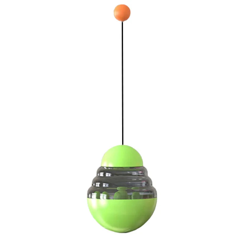 Green hanging treat dispensing ball toy with orange knob on a string