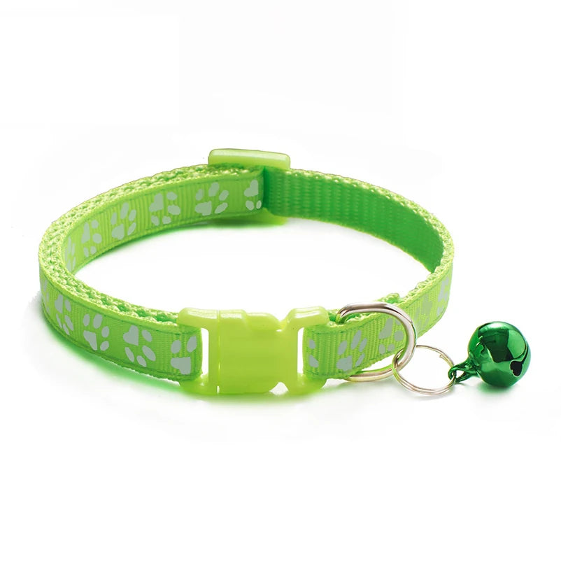 Green paw-print cat collar with plastic buckle and bell charm on a ring