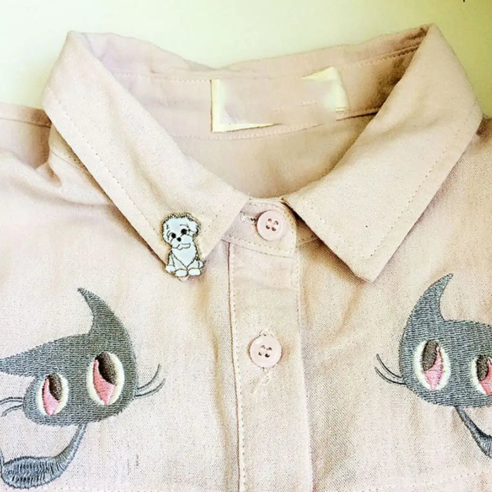 Enamel pin badge with cartoon dog design, small bulldog on a light shirt collar