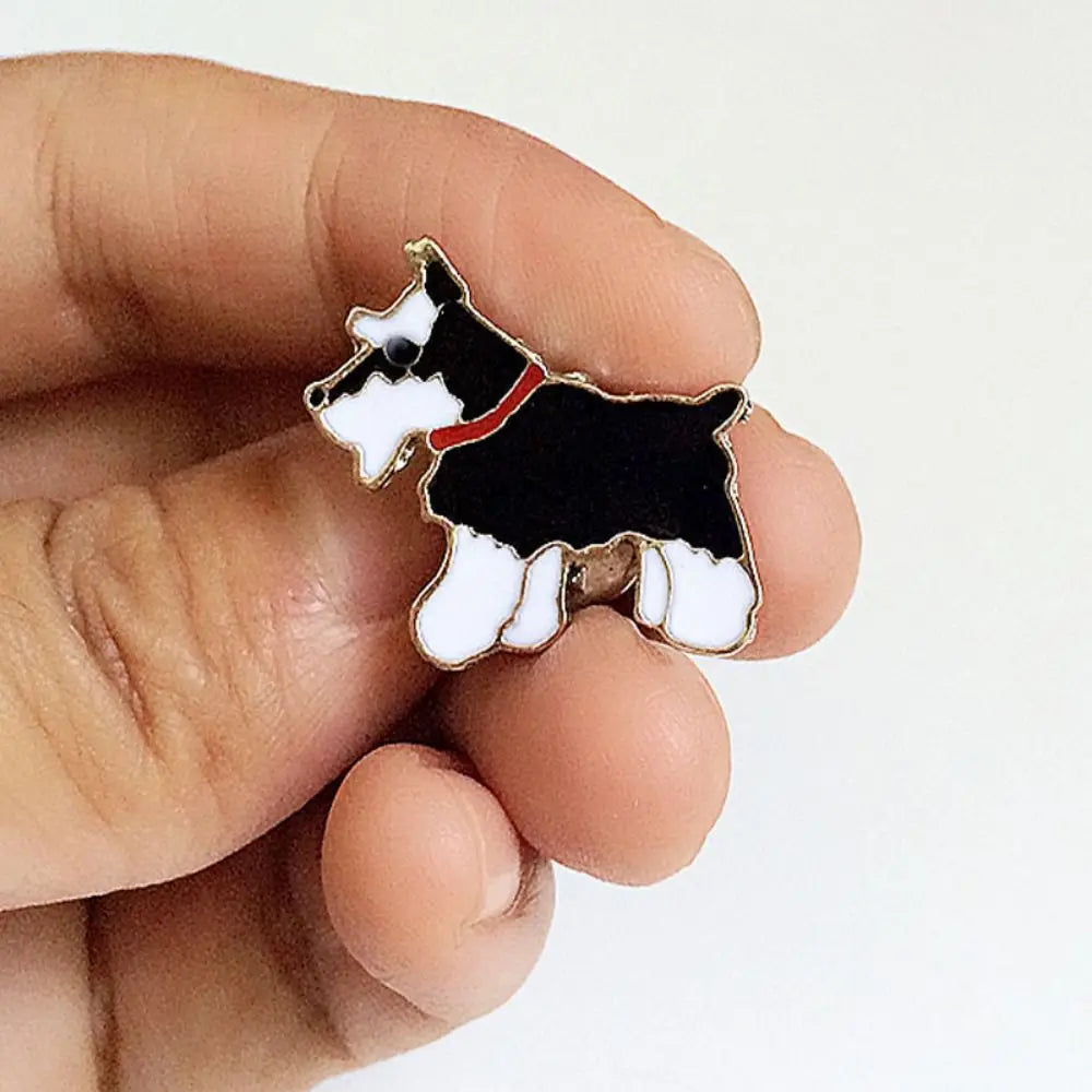 Cartoon black-and-white dog enamel pin with red collar on hand
