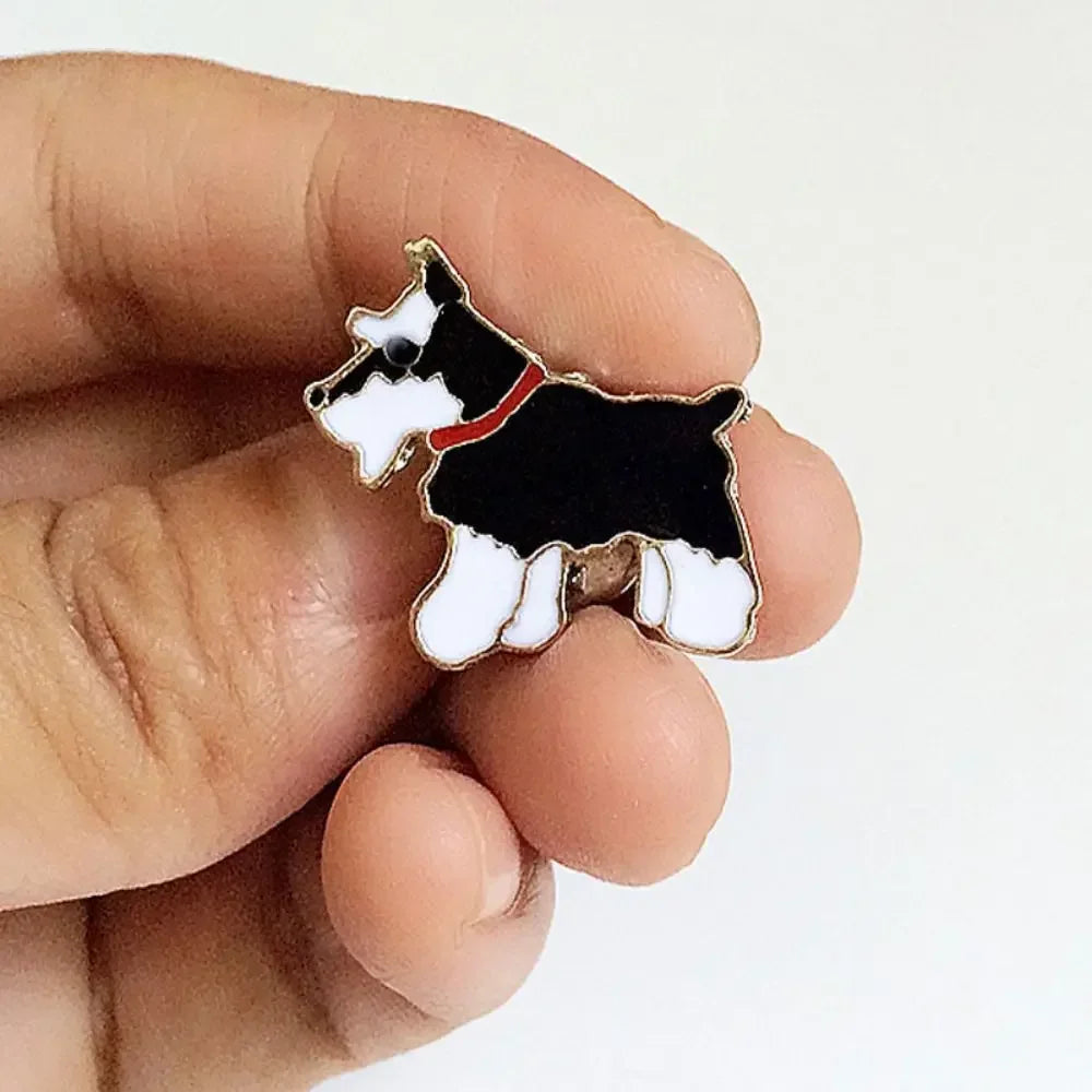 Dog enamel pin on hand: black and white cartoon dog with red collar