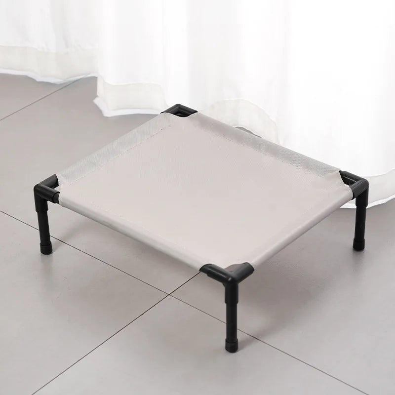 Outdoor elevated dog cot with light gray fabric cover and black metal legs