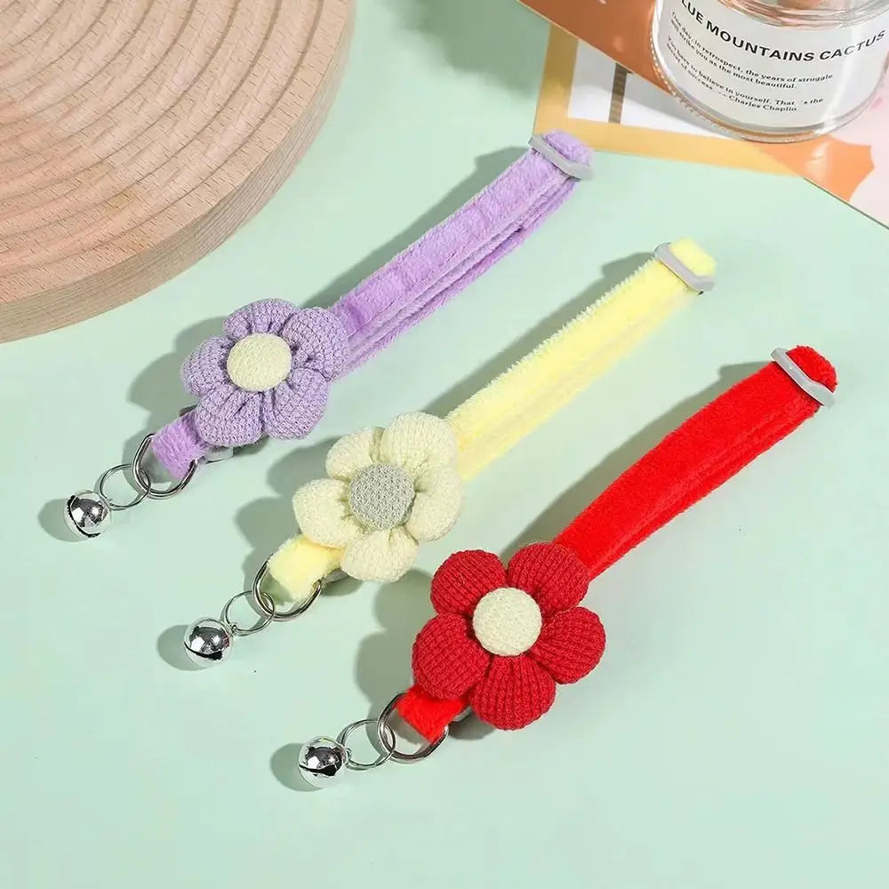 Two fabric flower cat collars in purple and red with small metal bell