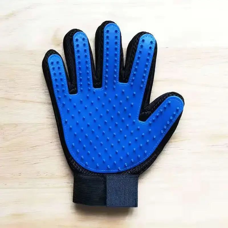 Blue cat grooming glove with raised silicone nubs and black cuff on tabletop