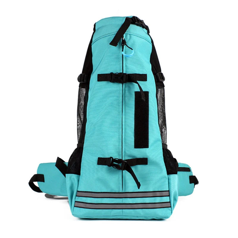 Turquoise dog backpack with black side panels, front strap, and adjustable leg openings