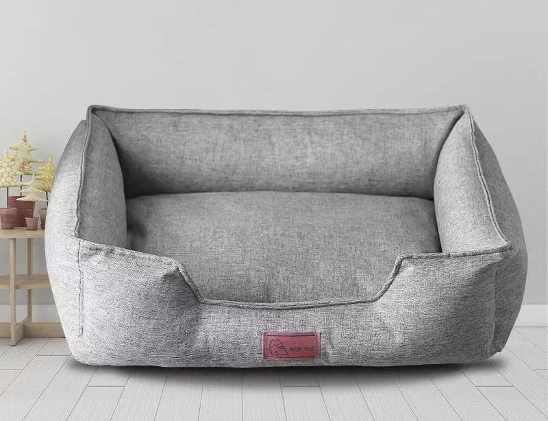 Gray pet mattress shown from the front, with padded bolsters and logo patch