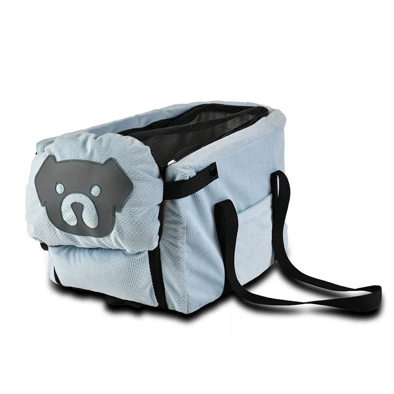 Pet carrier backpack bag in light blue with black straps and dog face patch front.