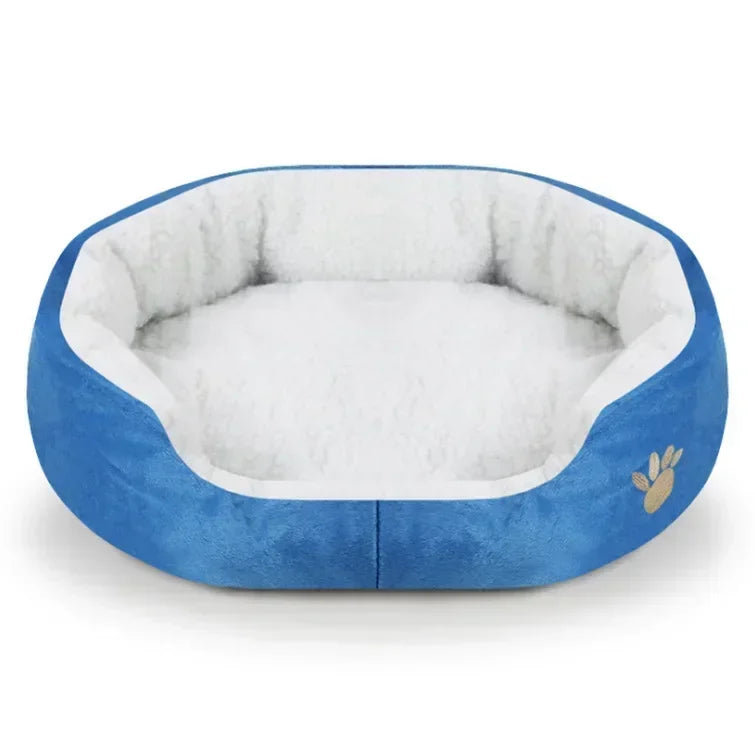 Blue plush oval dog bed with white cushioned center and paw emblem on the side