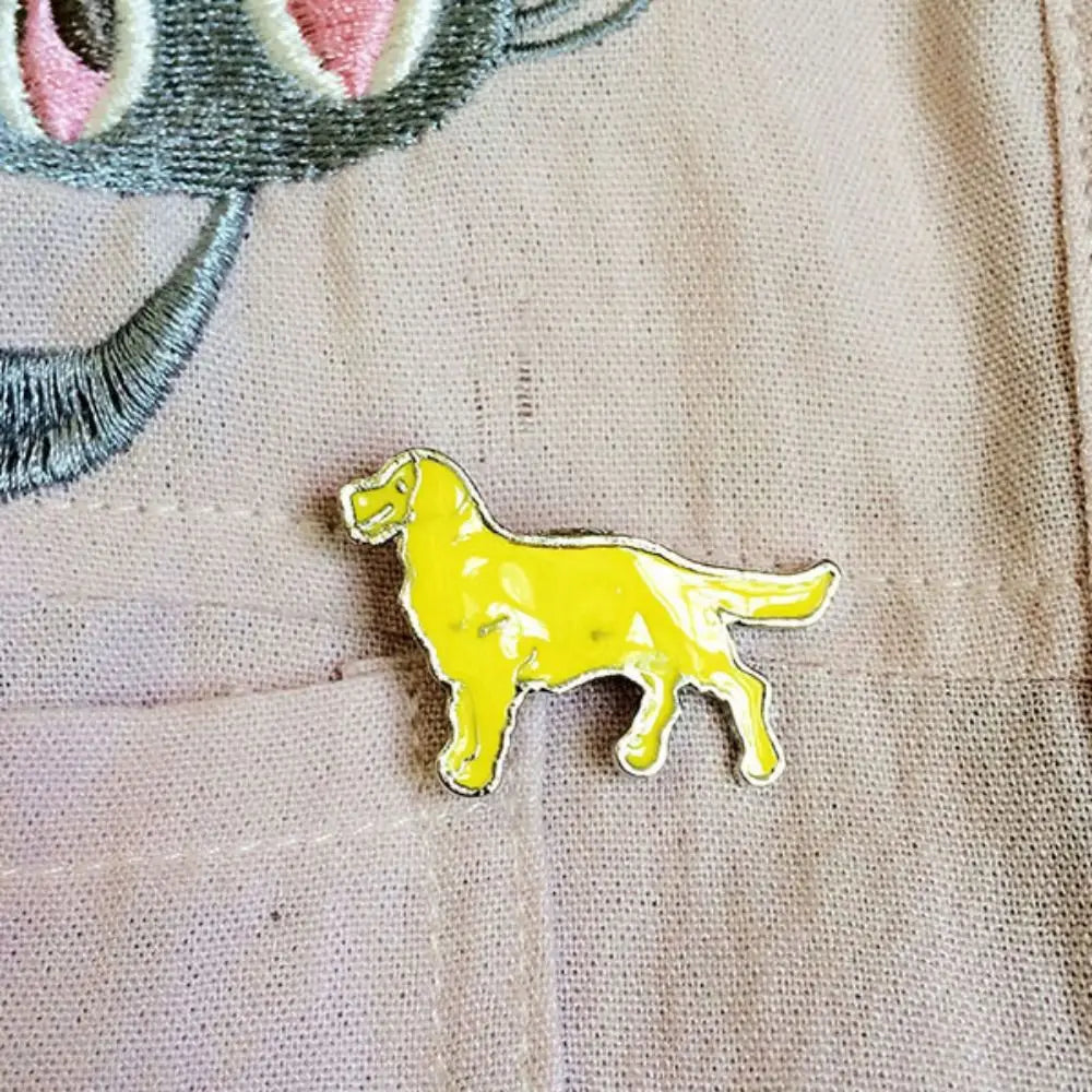 Cartoon yellow dog enamel pin on light fabric