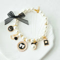 Pearl pet collar with black lace bow and circular charm medallion, white beads