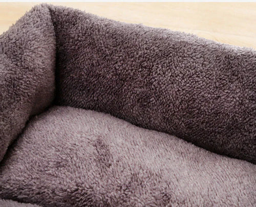 Plush dog bed interior with thick gray fuzzy bolster padding, scooped resting area