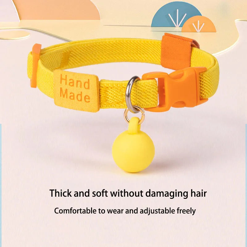 Yellow elastic adjustable cat collar with orange buckle and round bell charm