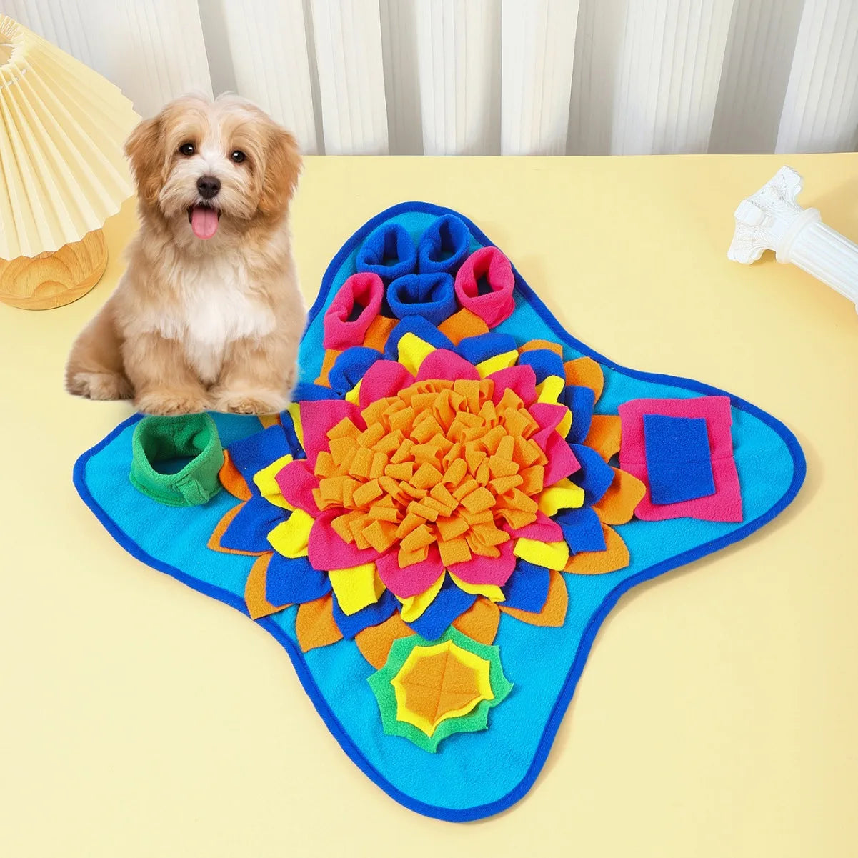 Interactive snuffle mat feeder with blue fabric, bright orange flower, and green pocket pieces