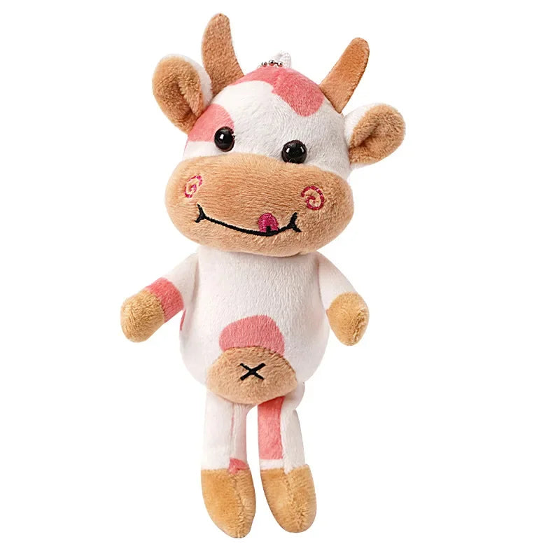 White and tan cow plush toy with pink spots and bead charm, full front view