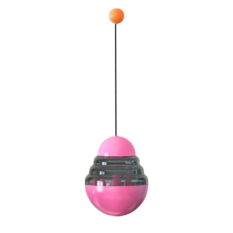 Pink hanging treat dispensing ball toy with orange knob on a string