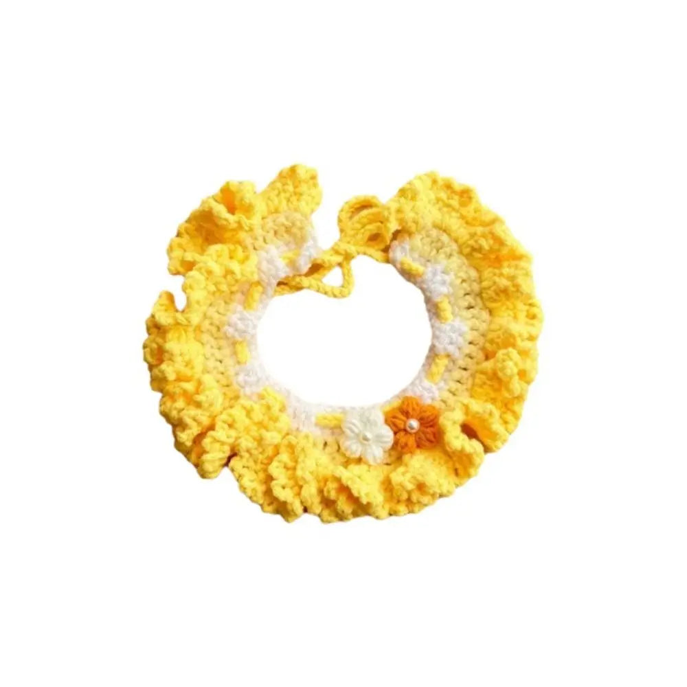 Yellow crocheted pet scarf bib with white trim, orange button, and flower detail