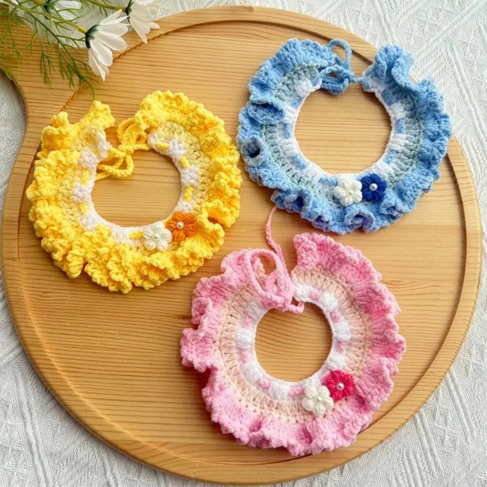 Crocheted pet scarf bibs in blue, yellow, and pink with white trim and flower details